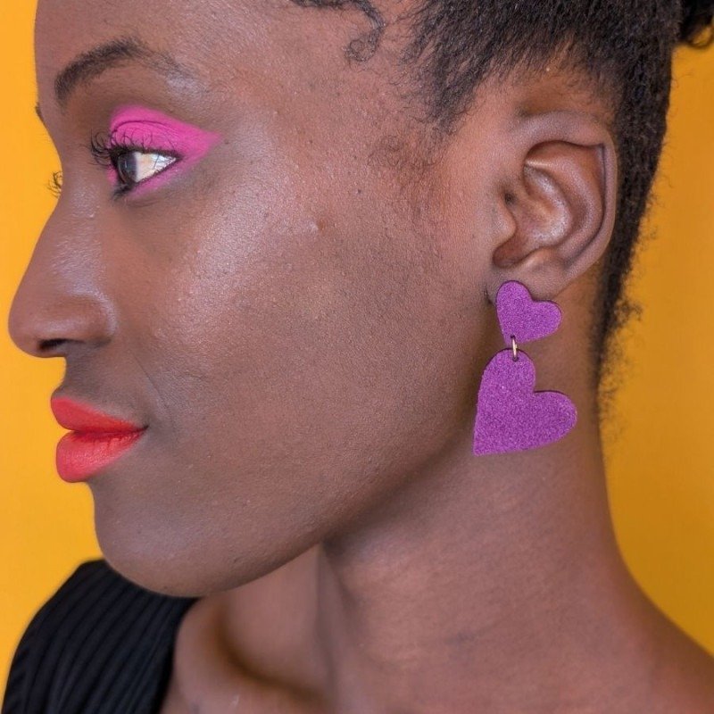 Boucles d’oreilles double cœur Bibiche Aubergine de Demisel portées à l’oreille.