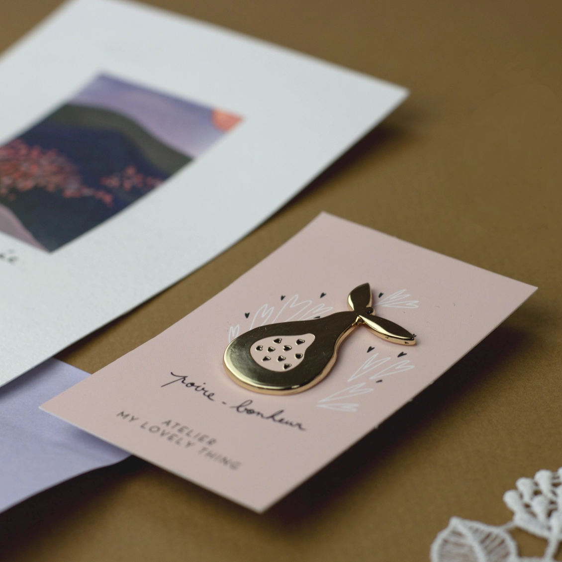Pin’s Poire William doré My Lovely Thing présenté sur sa carte illustrée Poire-bonheur.